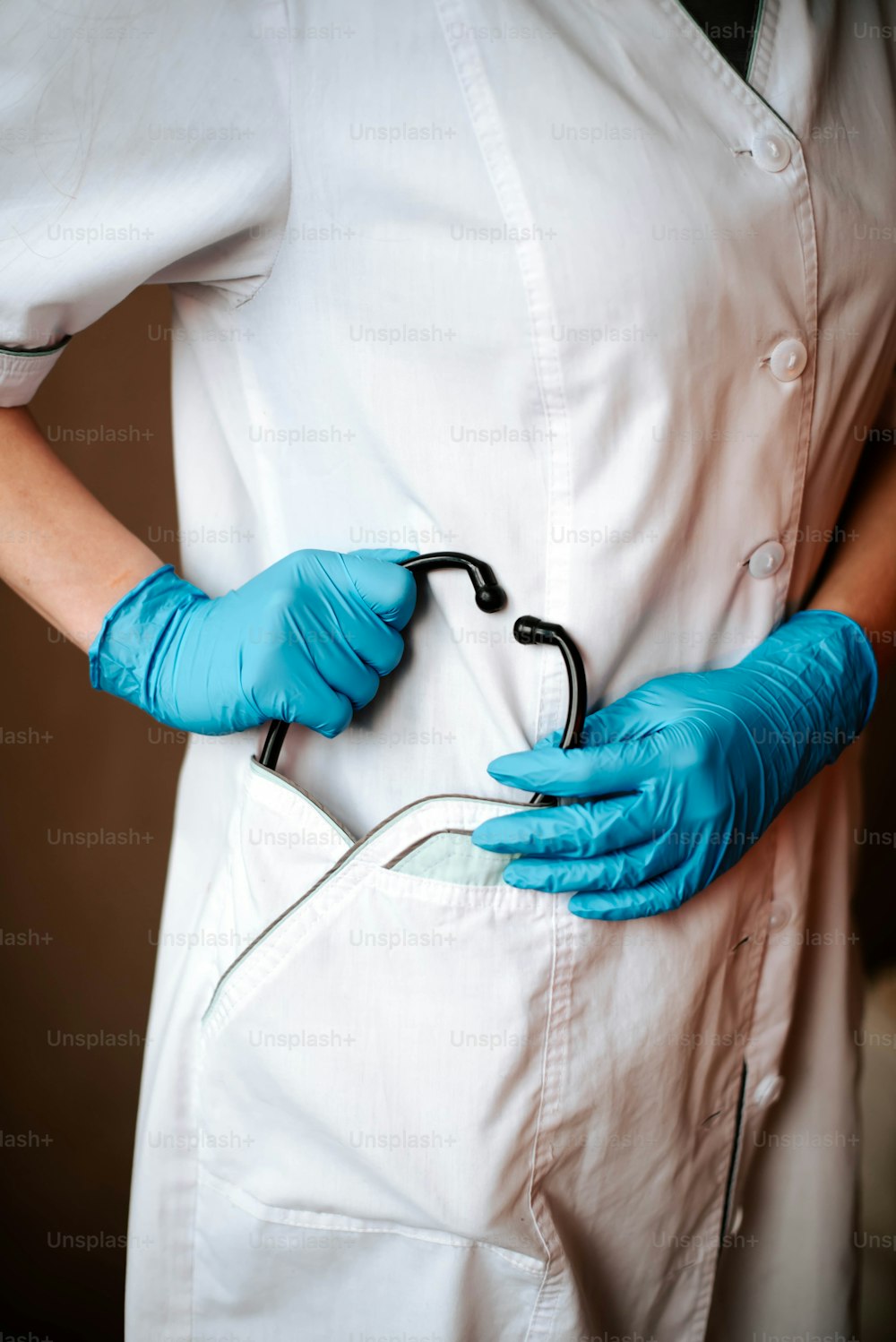 a person wearing blue gloves holding a pair of scissors