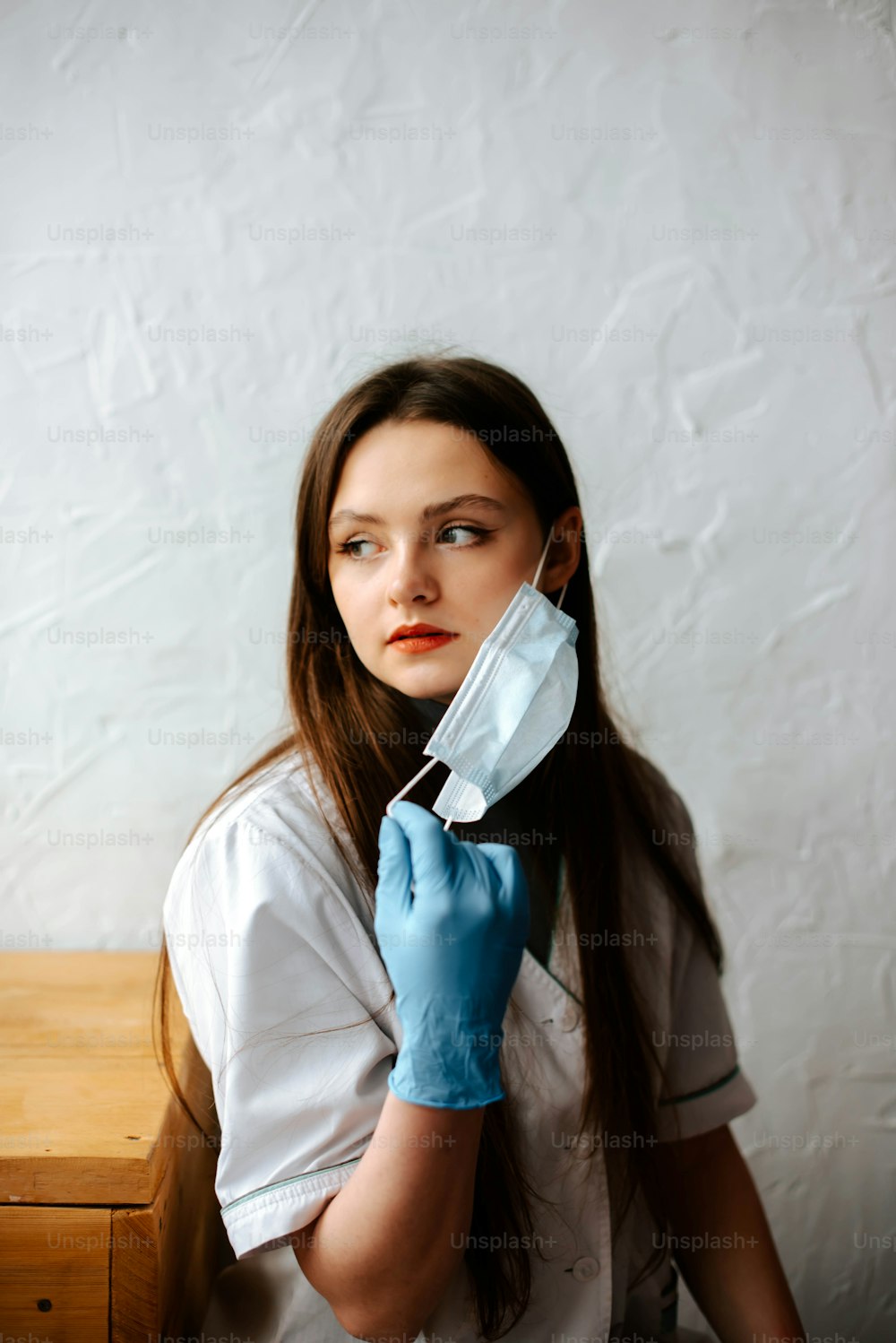 Une femme en chemise blanche et gants bleus