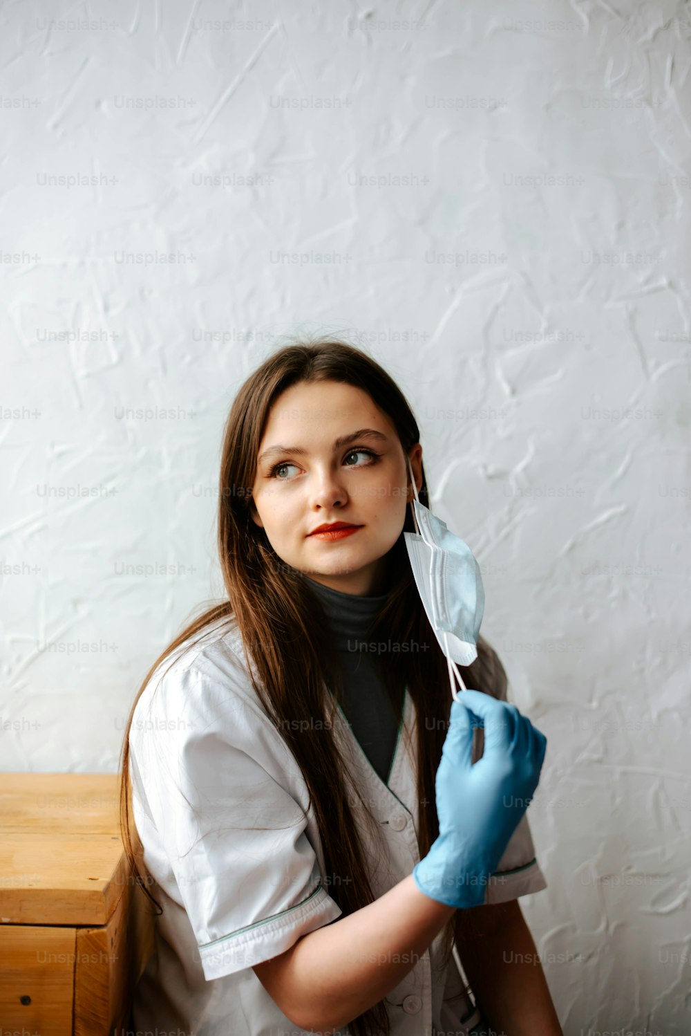 a woman in a white shirt and blue gloves