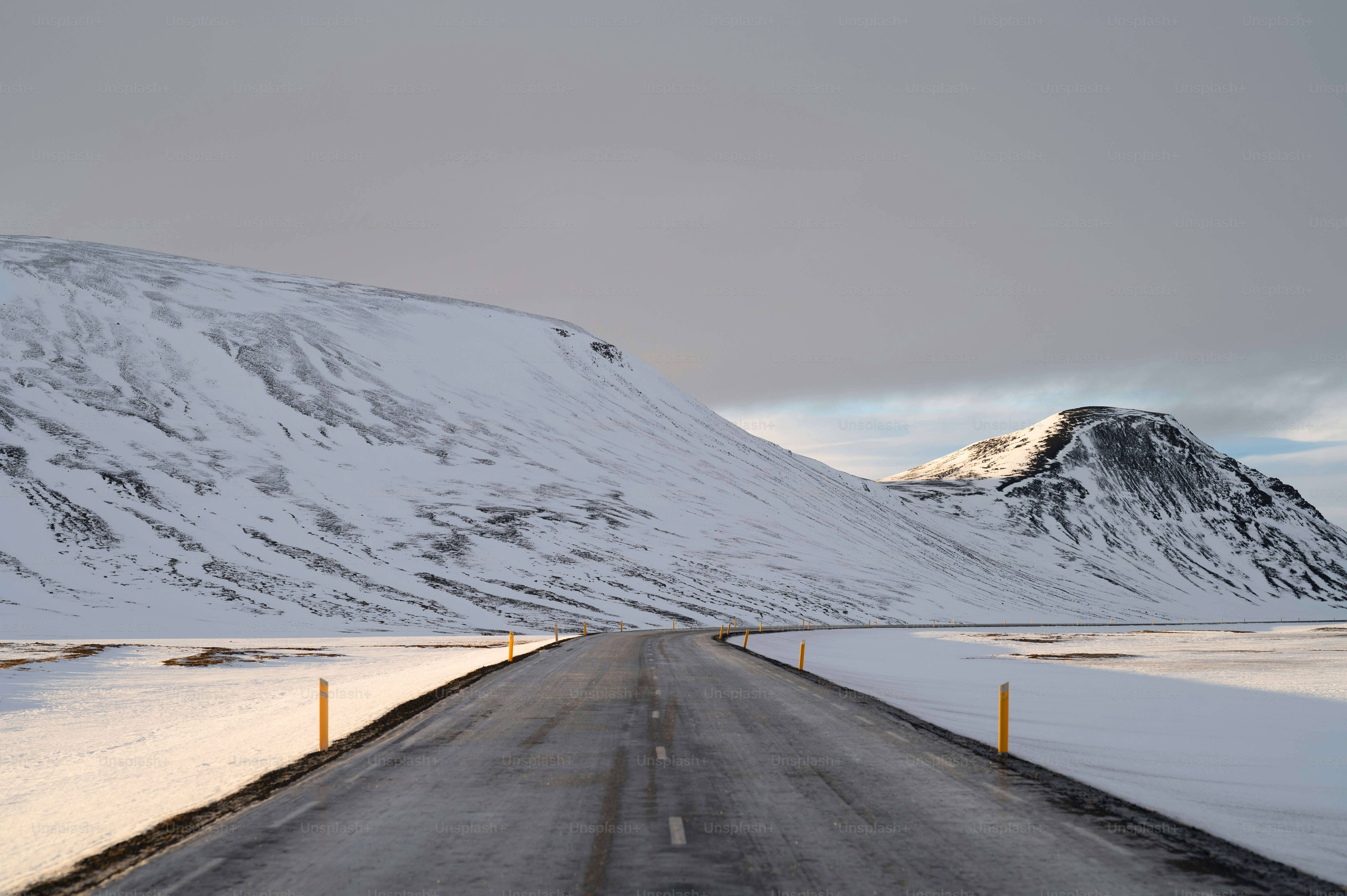 a snow covered mountain with a road in the foreground