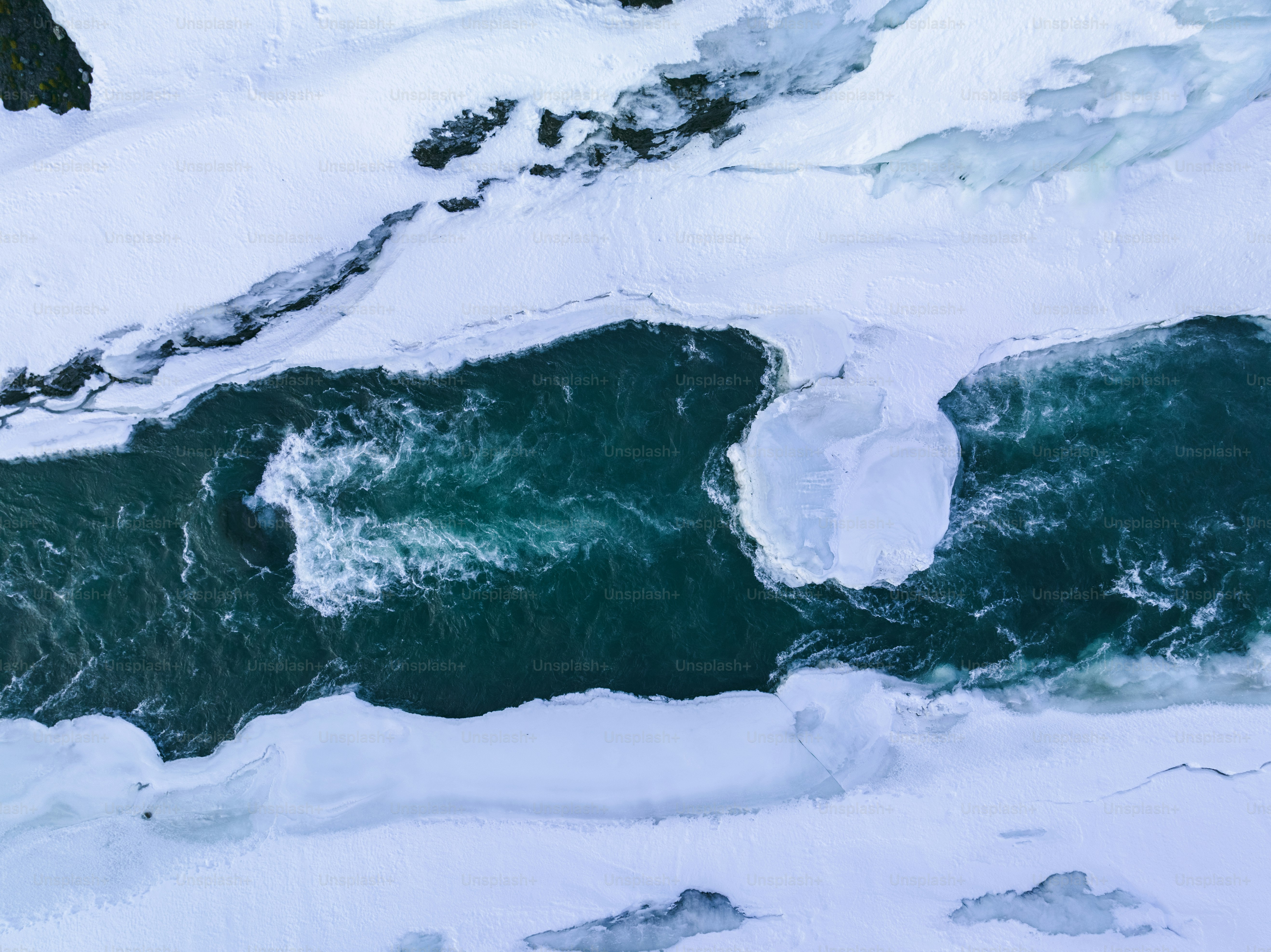 an aerial view of the water and snow