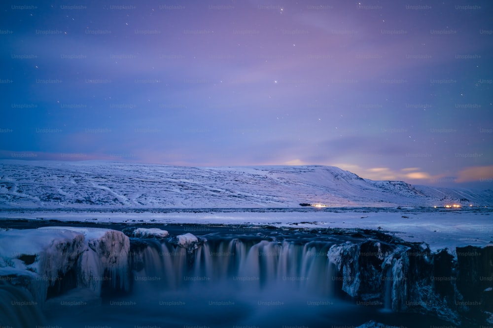a frozen waterfall in the middle of a snowy landscape