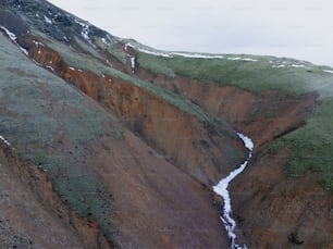 una ladera de la montaña con una corriente de agua que sale de ella