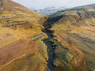 a river running through a valley surrounded by mountains