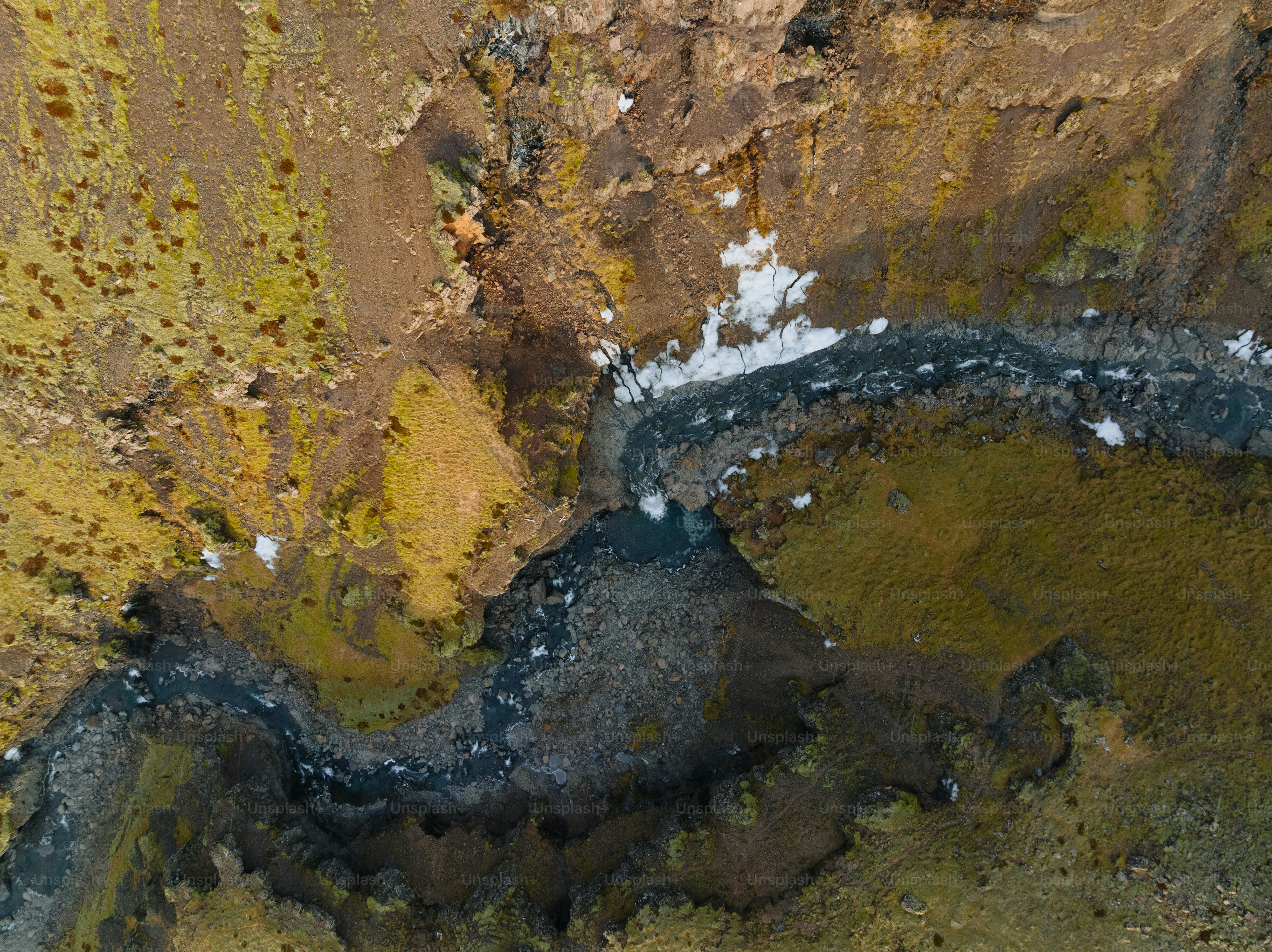 an aerial view of a river in a rocky area