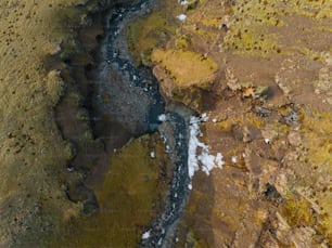 an aerial view of a river running through a field