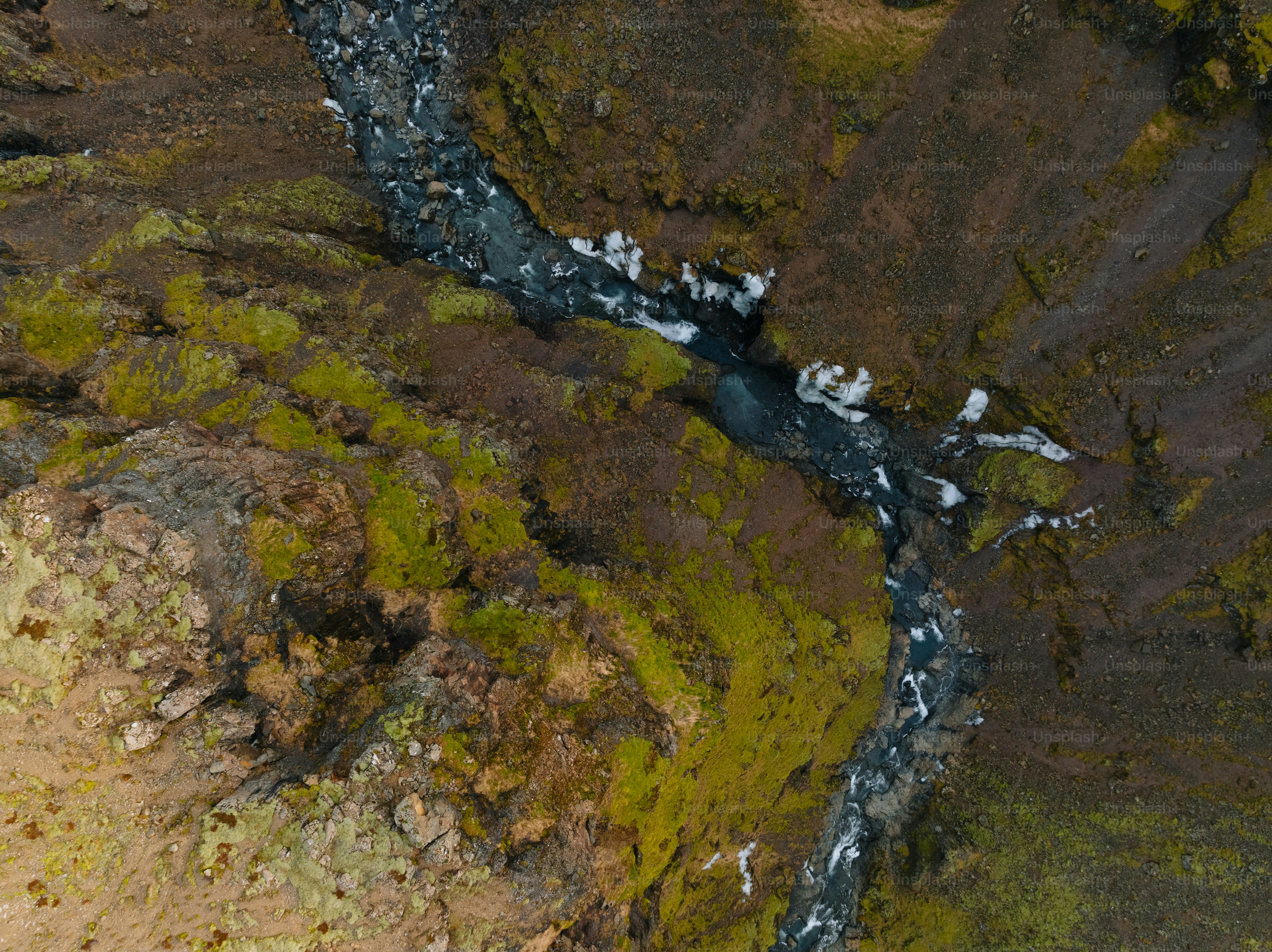 an aerial view of a stream in a rocky area