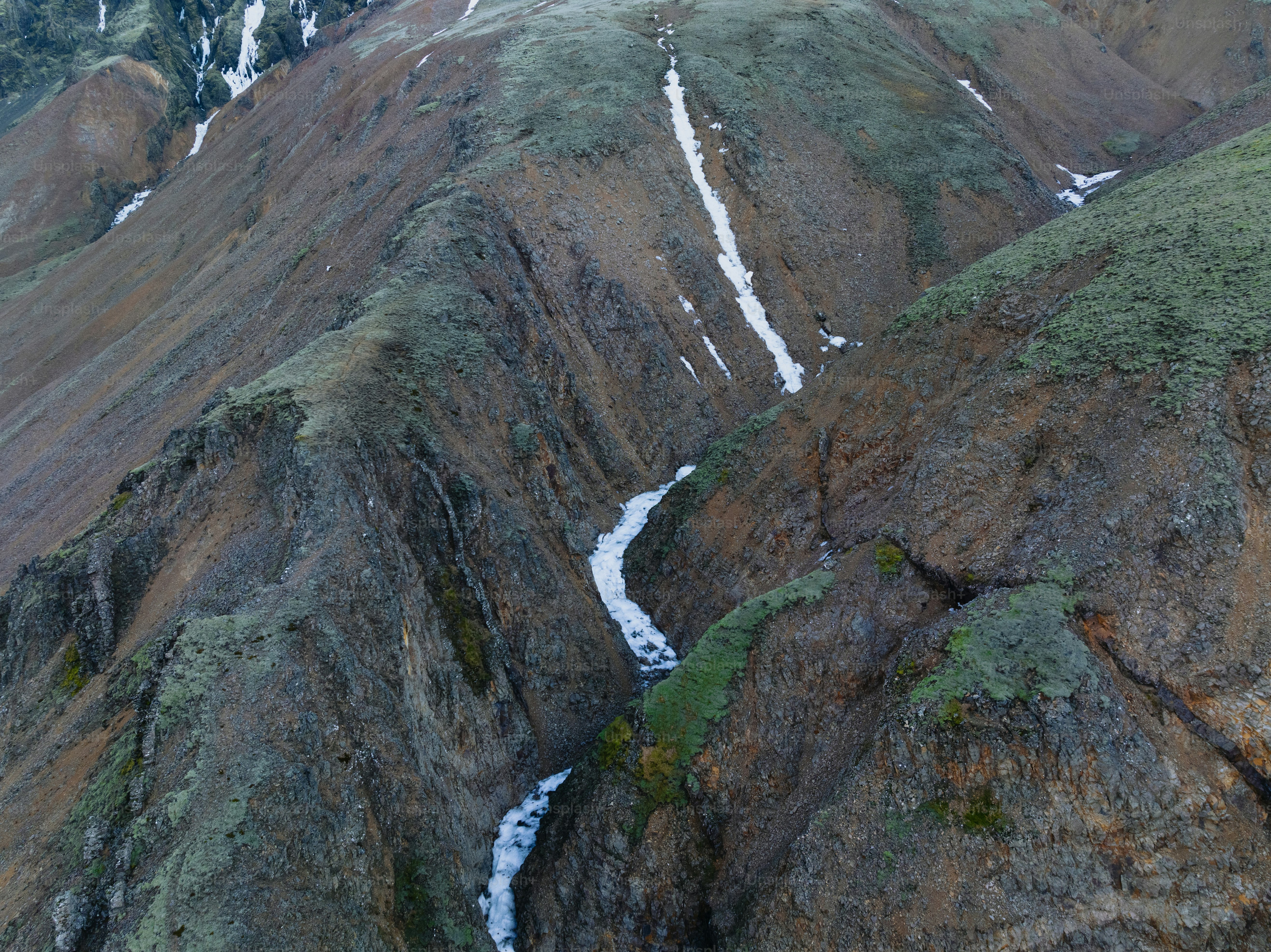 a view of a mountain with a stream running through it