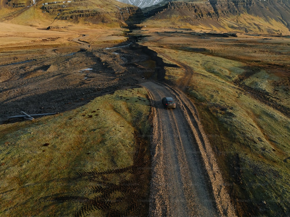 um caminhão dirigindo por uma estrada de terra nas montanhas