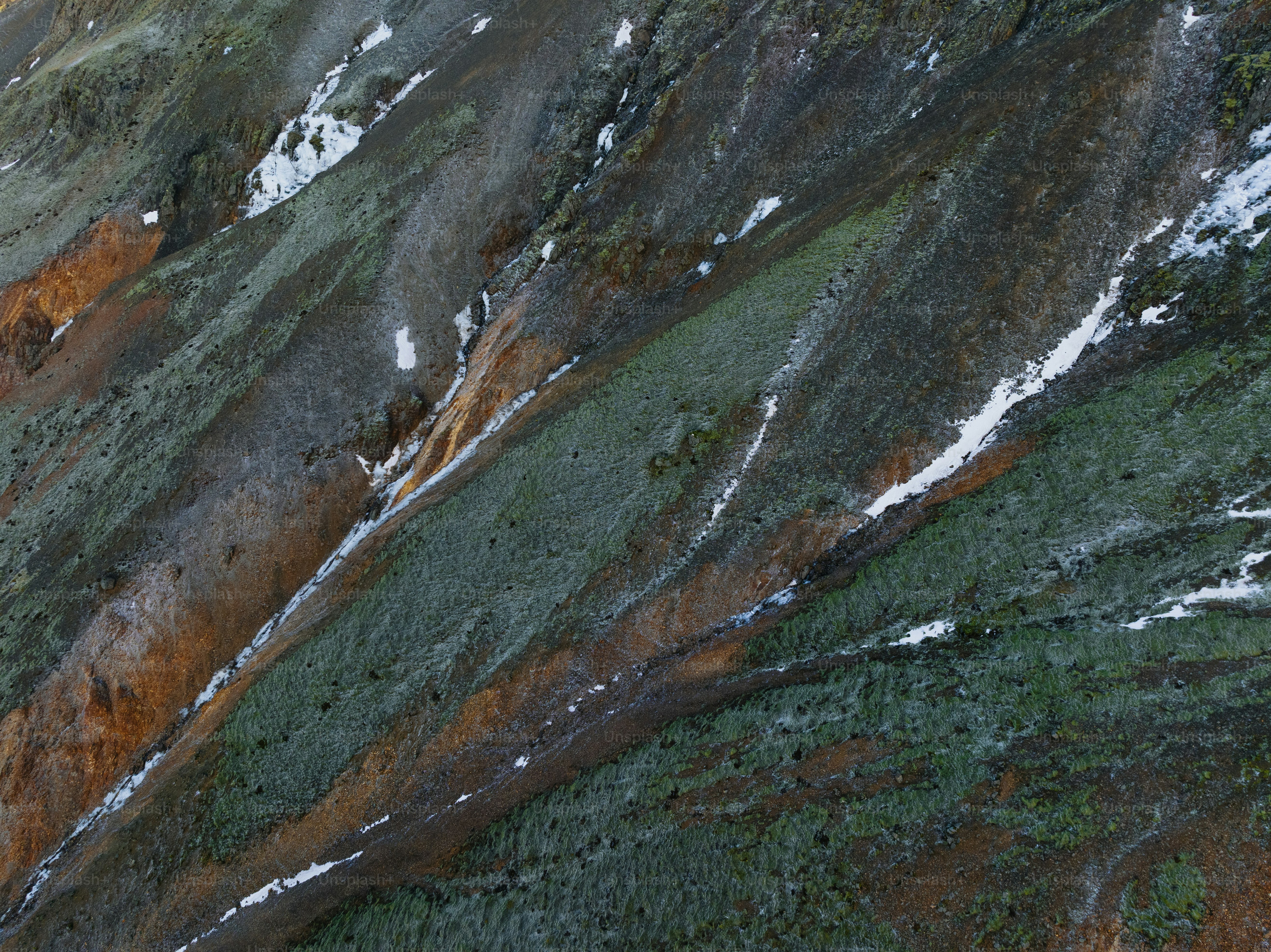 une vue aérienne d’une montagne avec de la neige dessus