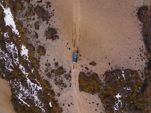 Luftaufnahme eines Autos, das auf einer unbefestigten Straße fährt
