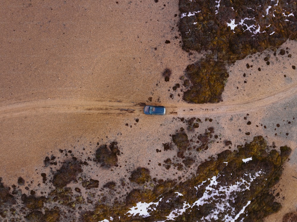 une vue aérienne d’une voiture roulant sur un chemin de terre