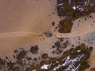 Una vista aerea di un'auto che guida su una strada sterrata