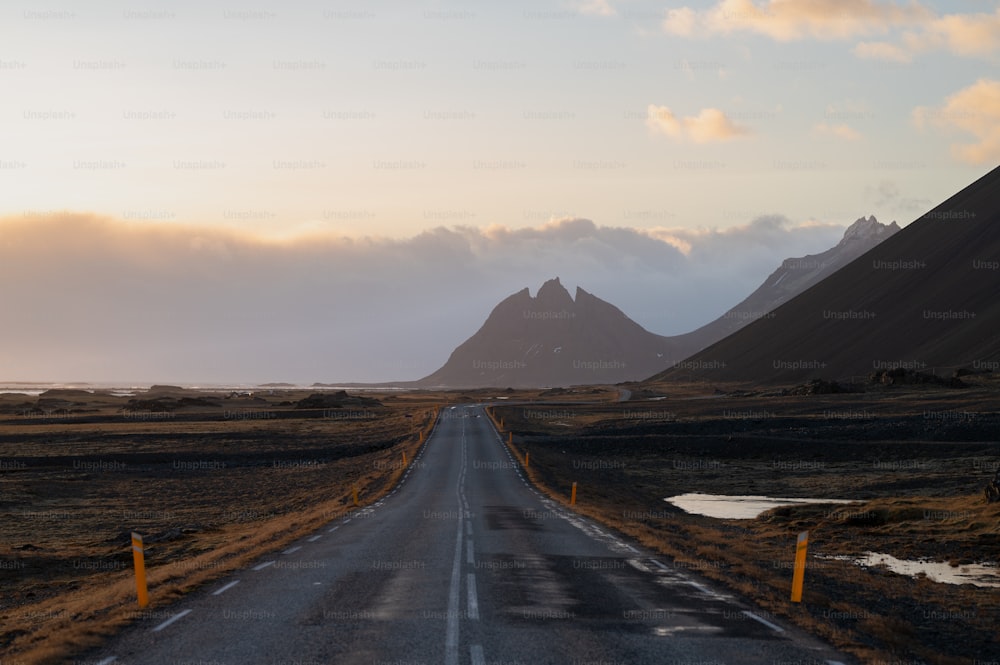 an empty road with mountains in the background