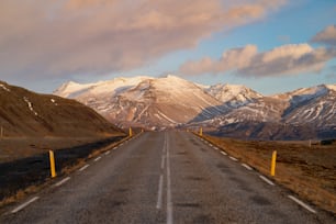 an empty road with mountains in the background