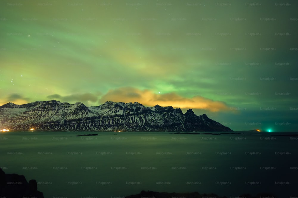 a mountain covered in snow under a green sky