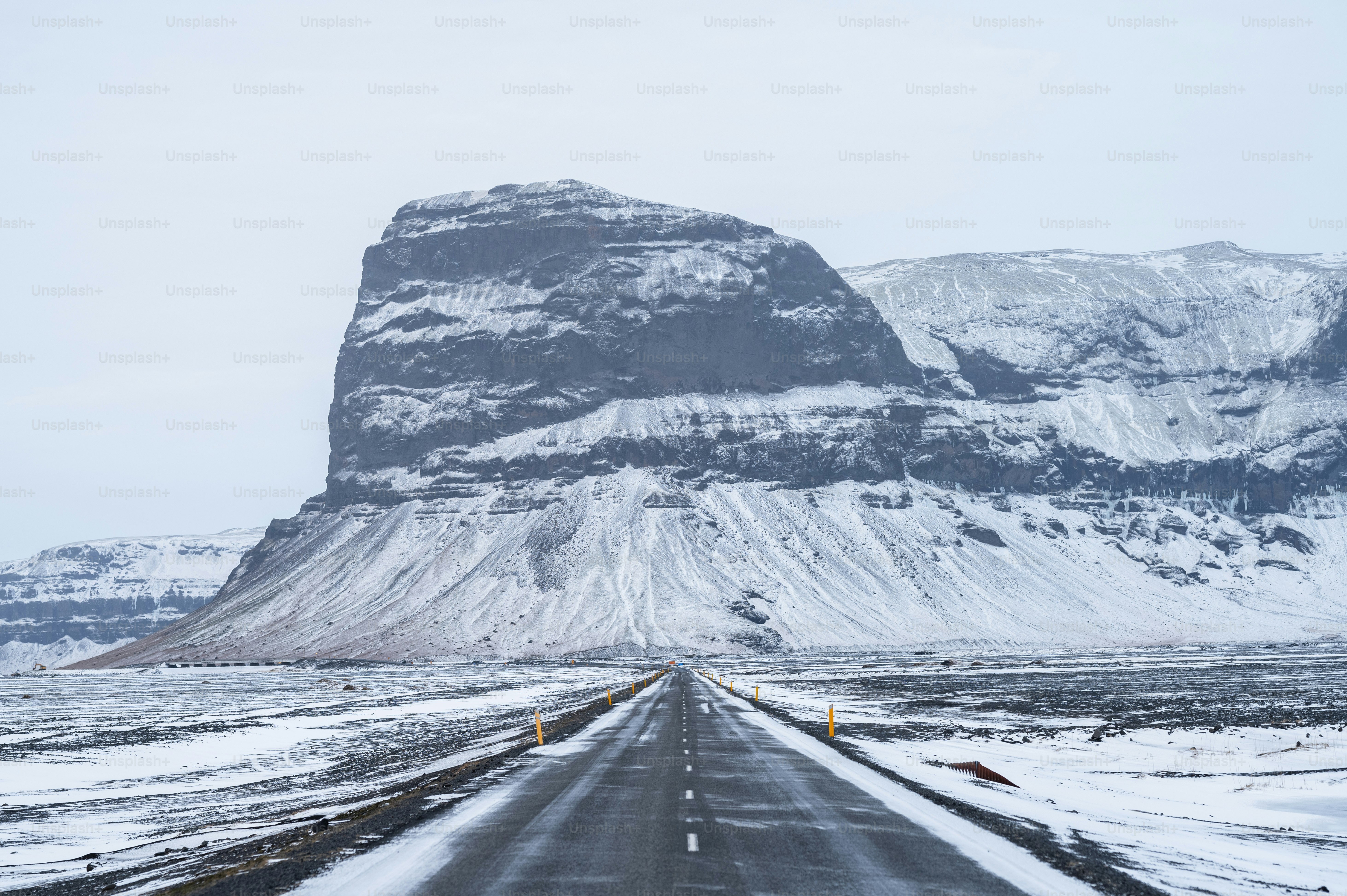 Eine lange Straße mit einem Berg im Hintergrund