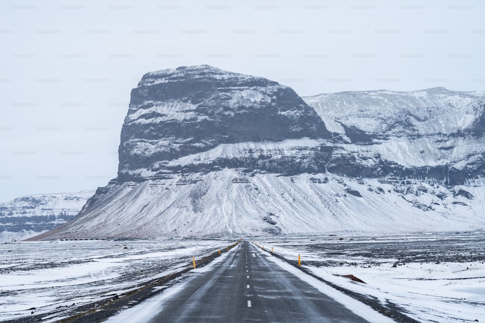 Eine lange Straße mit einem Berg im Hintergrund