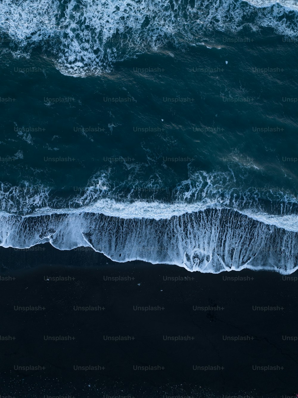 Una vista aérea del océano con olas rompiendo en la orilla