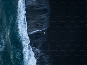 une vue aérienne de l’océan et une plage de sable noir