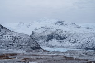 a snowy mountain range with a glacier in the foreground