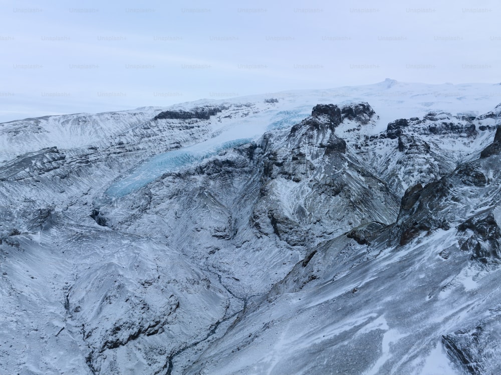 Una montagna innevata con un ghiacciaio in lontananza