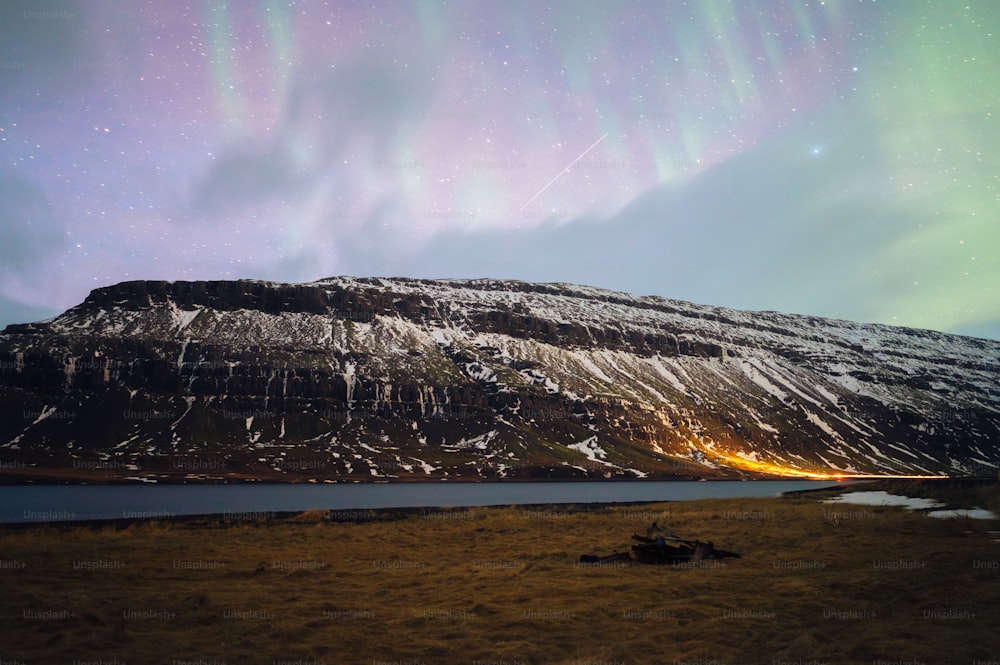 a mountain covered in snow under a purple sky