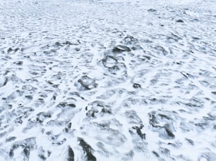 a snow covered beach with footprints in the snow