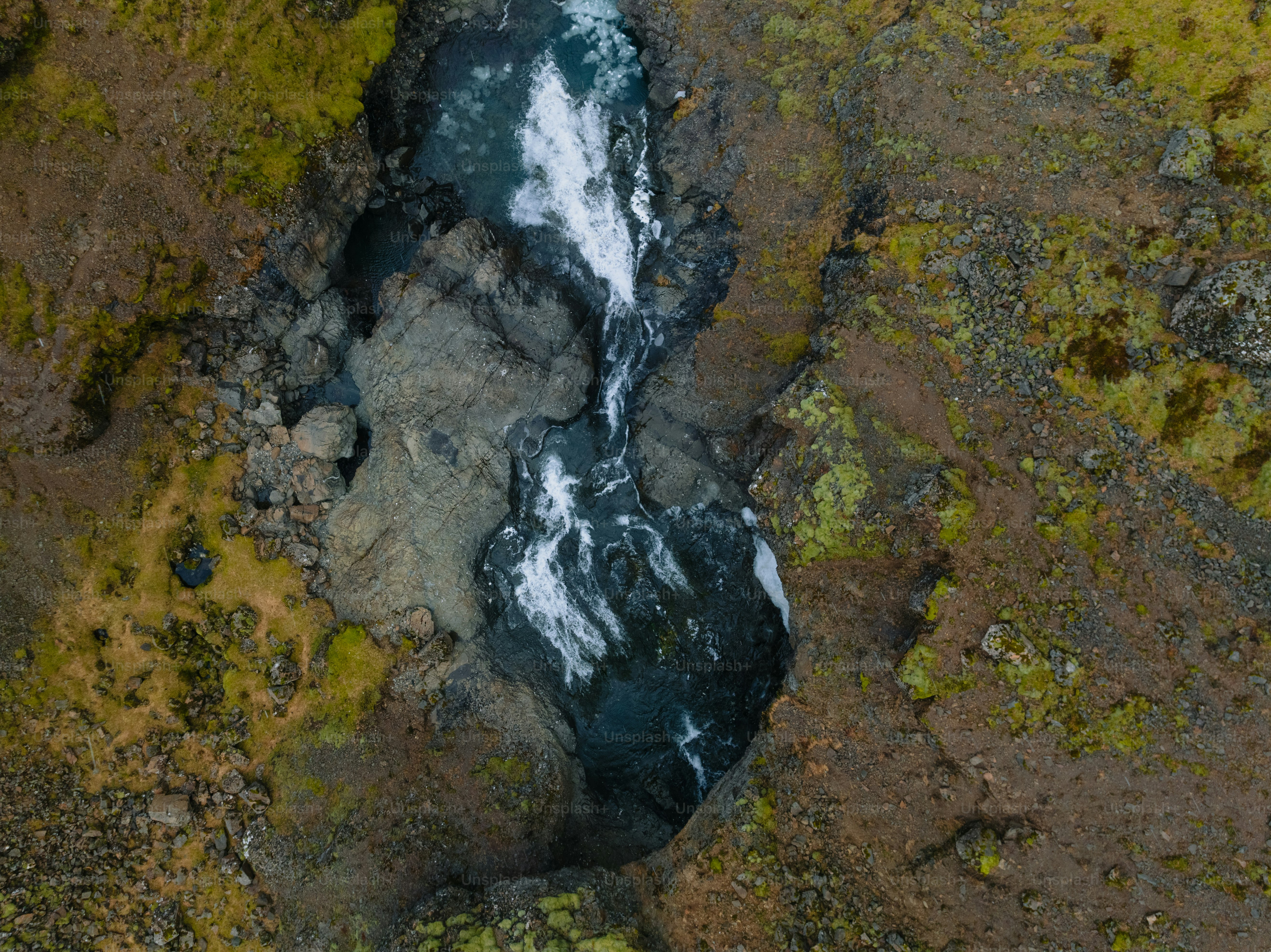 an aerial view of a river running through a rocky area