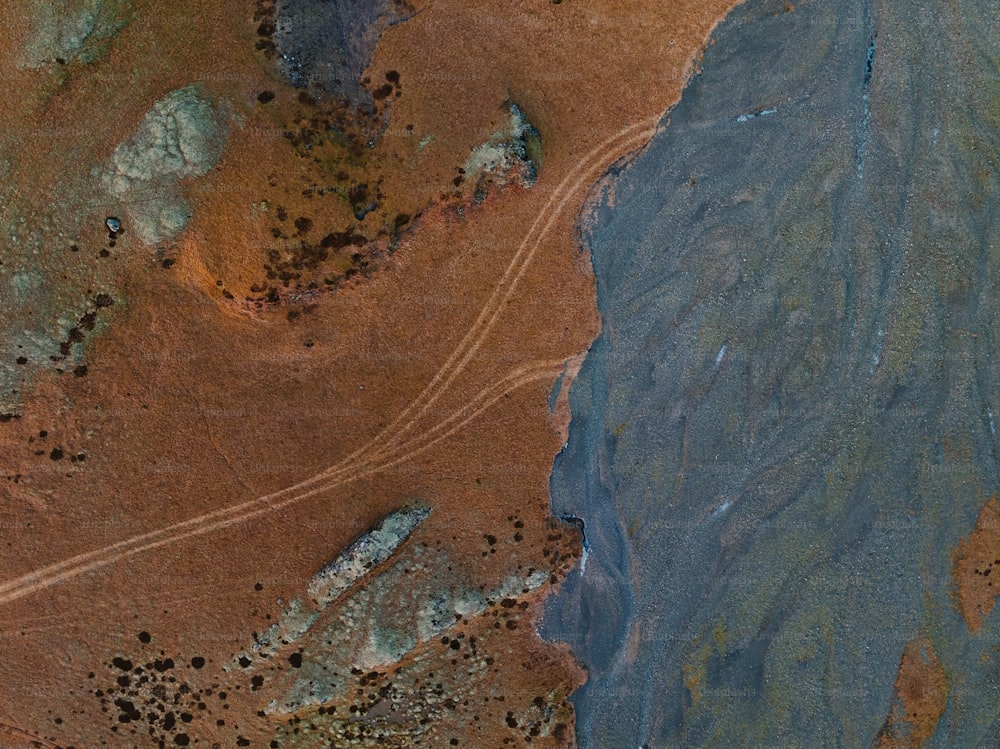 a bird's eye view of a dirt field and a body of water