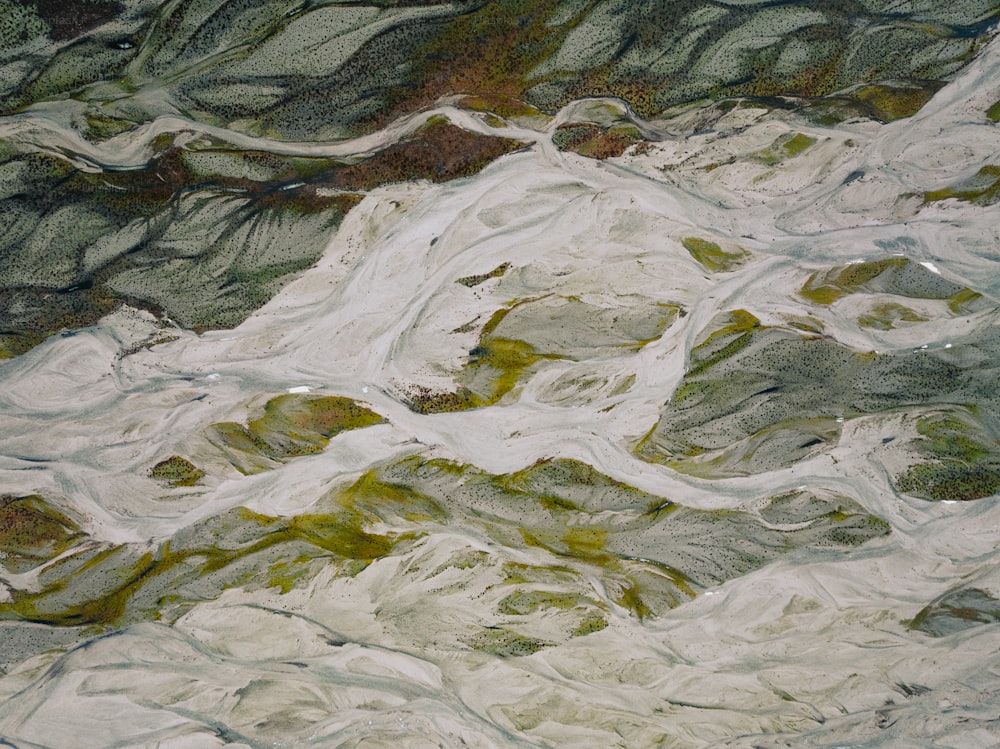 uma vista aérea de uma cordilheira com rochas verdes e brancas