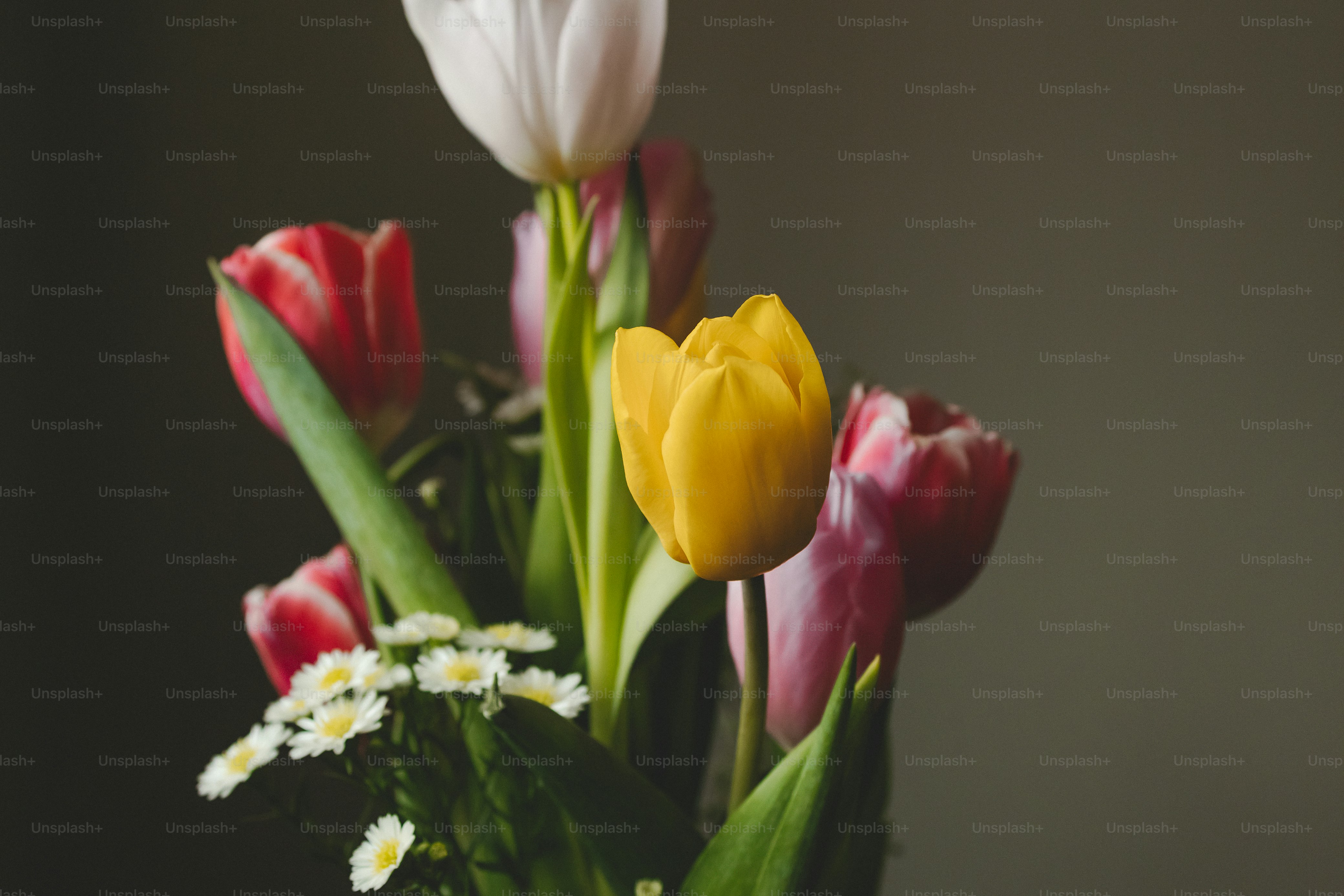 a vase filled with lots of different colored flowers