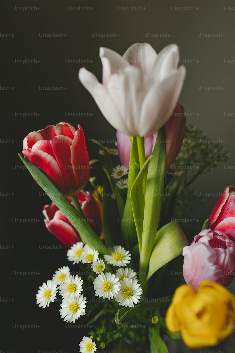 eine Vase gefüllt mit vielen verschiedenfarbigen Blumen