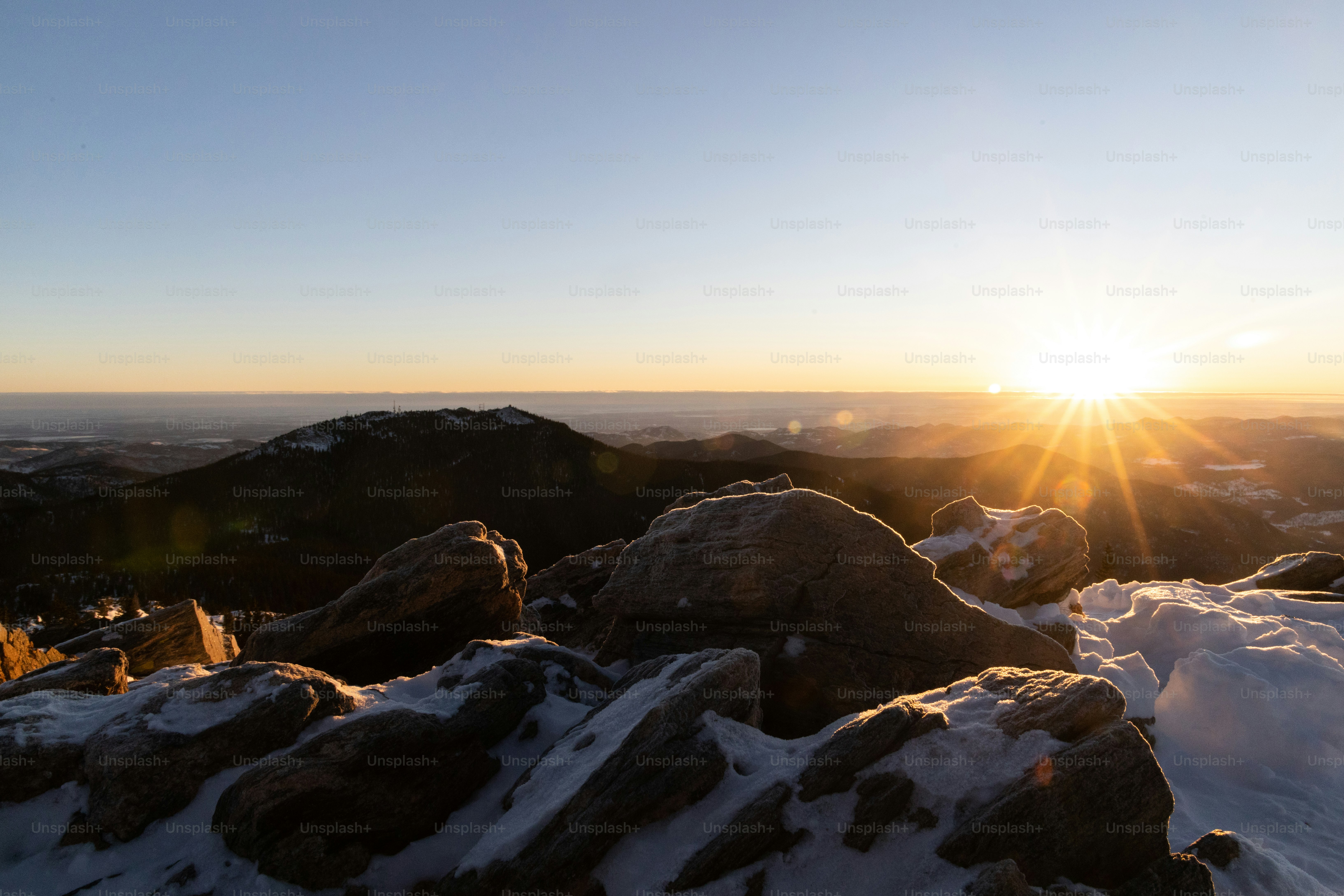 the sun is setting over a mountain range