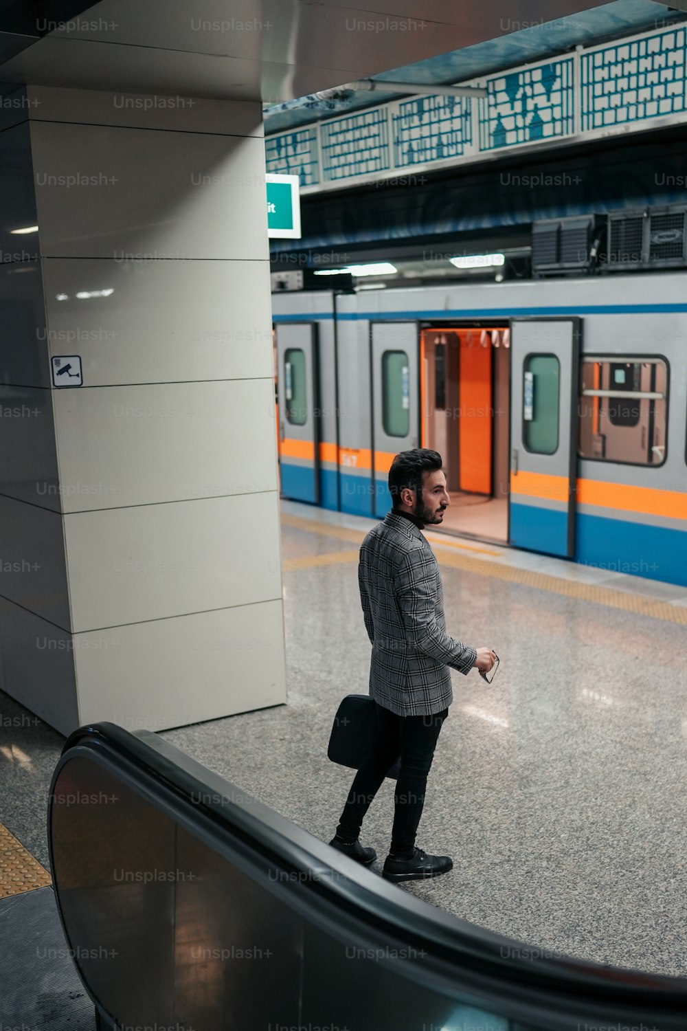 a man standing in front of a subway train