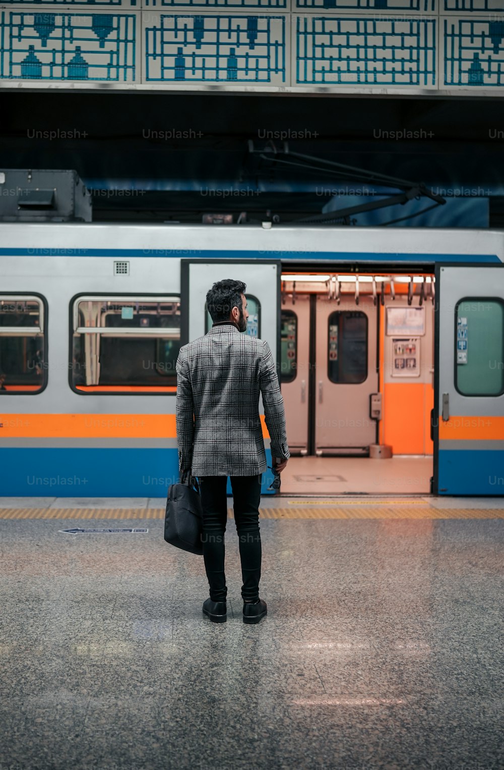 Un homme debout devant un train dans une gare