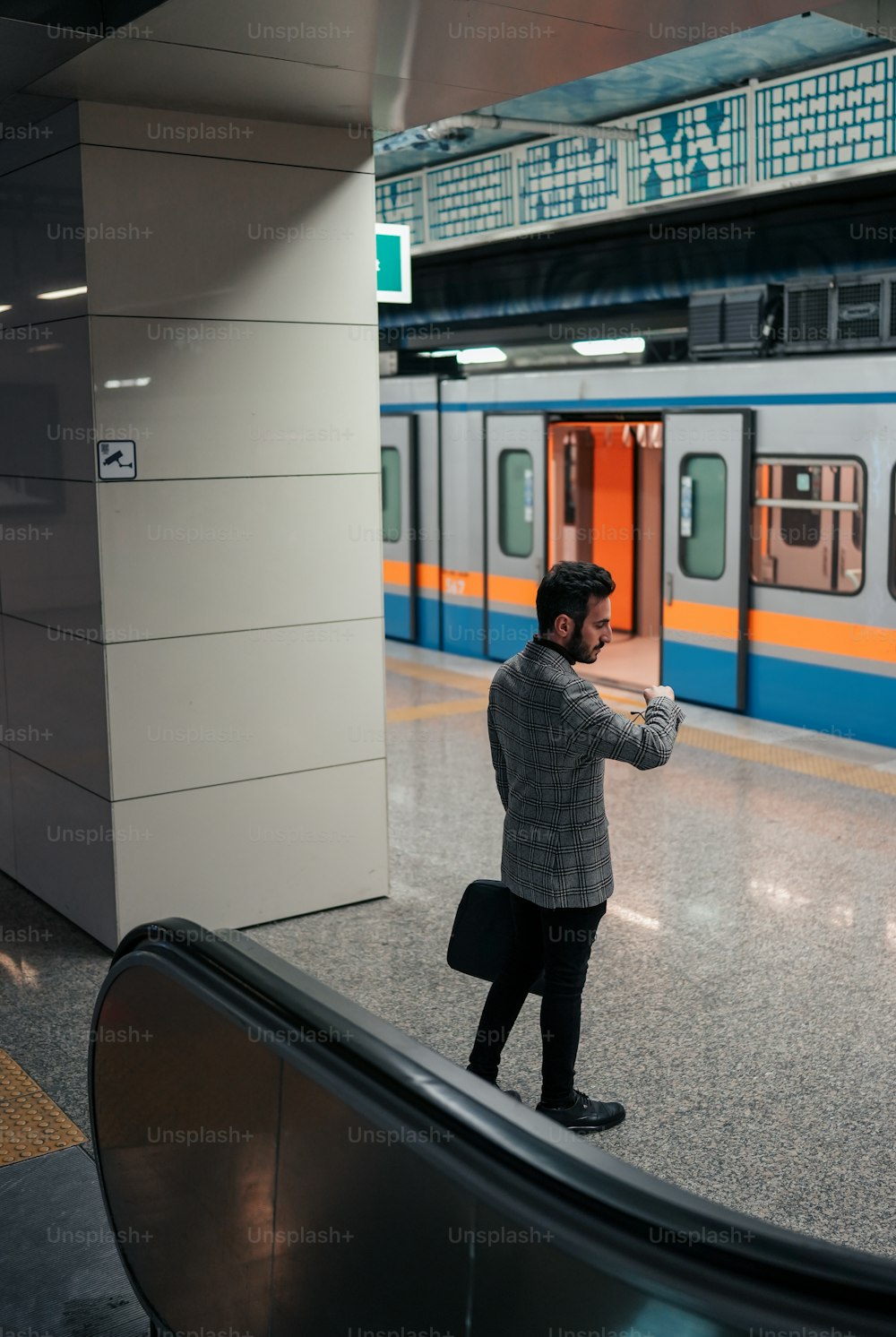 um homem tirando uma foto de si mesmo em uma estação de trem