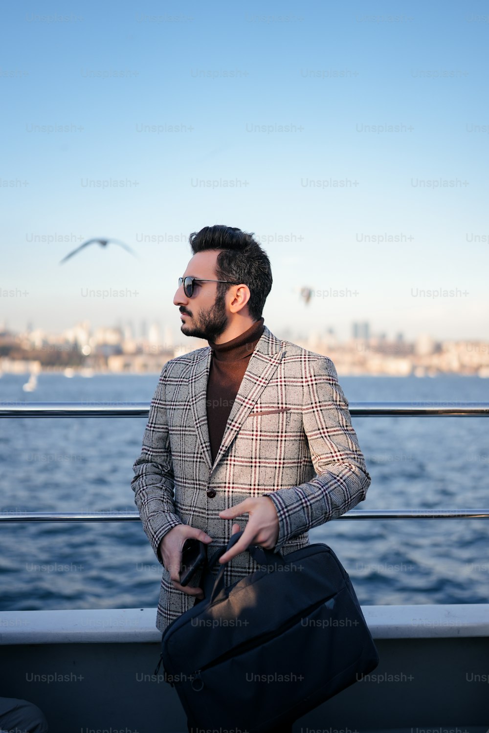 a man in a suit and sunglasses standing on a boat
