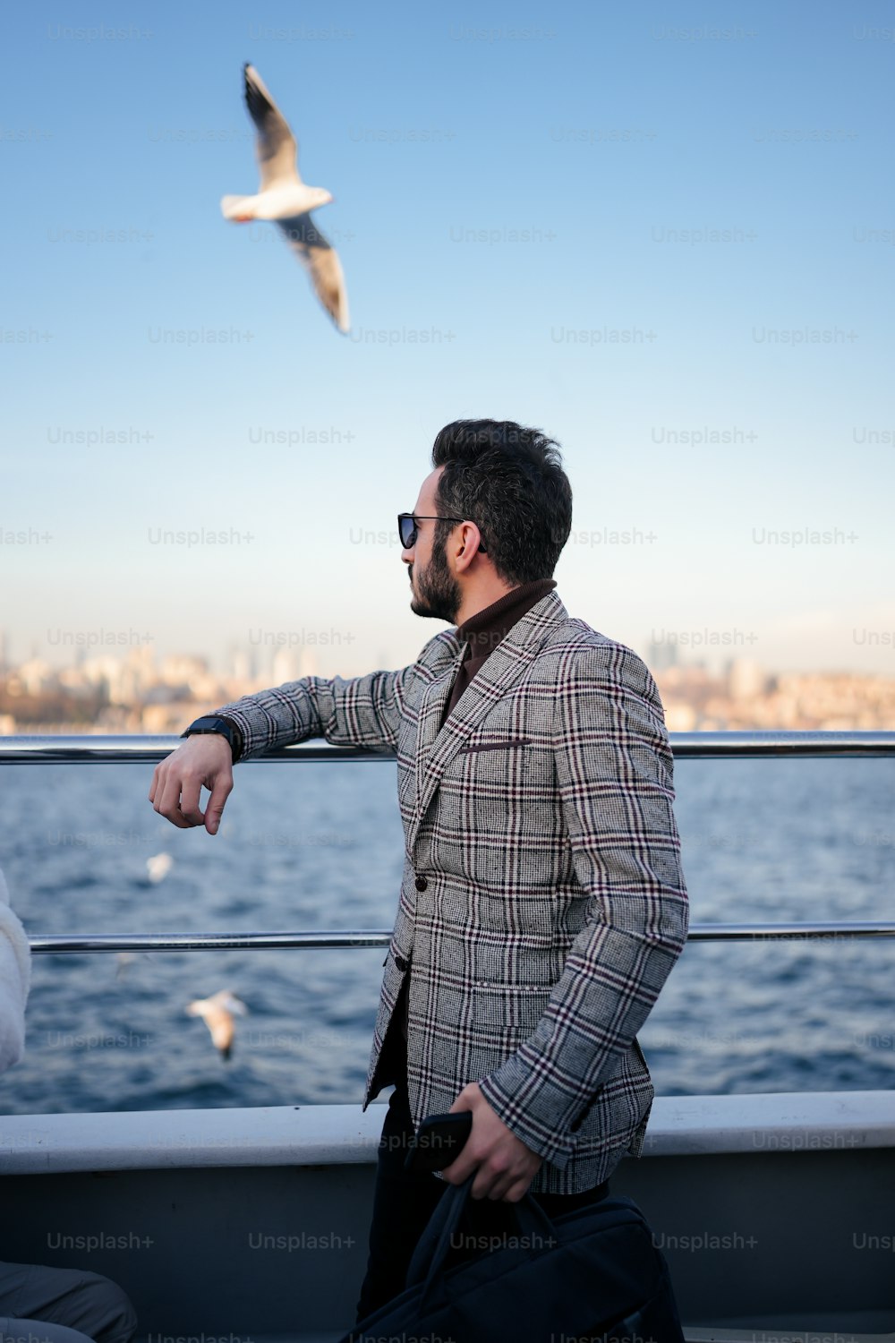 Ein Mann steht auf einem Boot und schaut auf eine Möwe