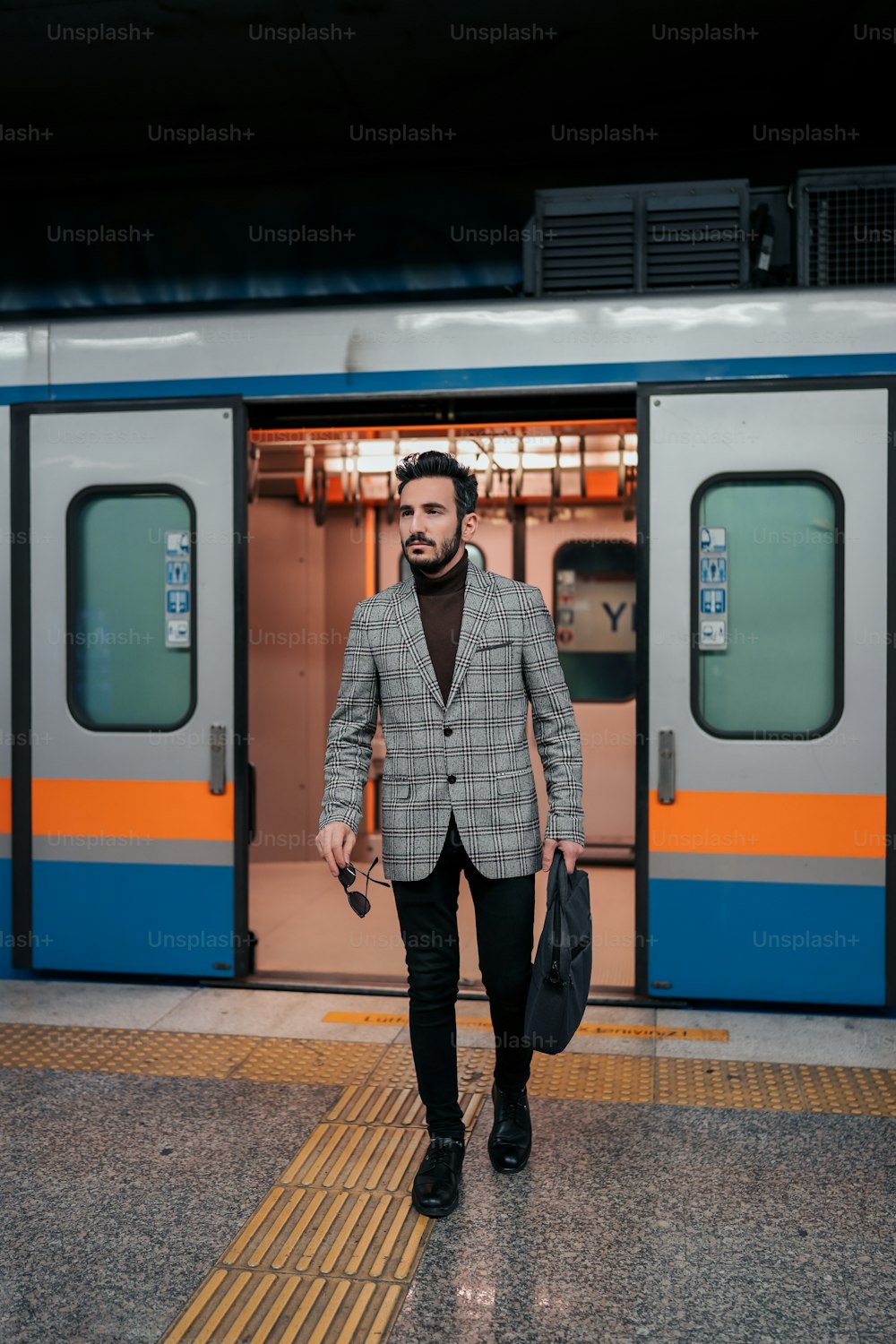 a man in a suit is walking towards a train