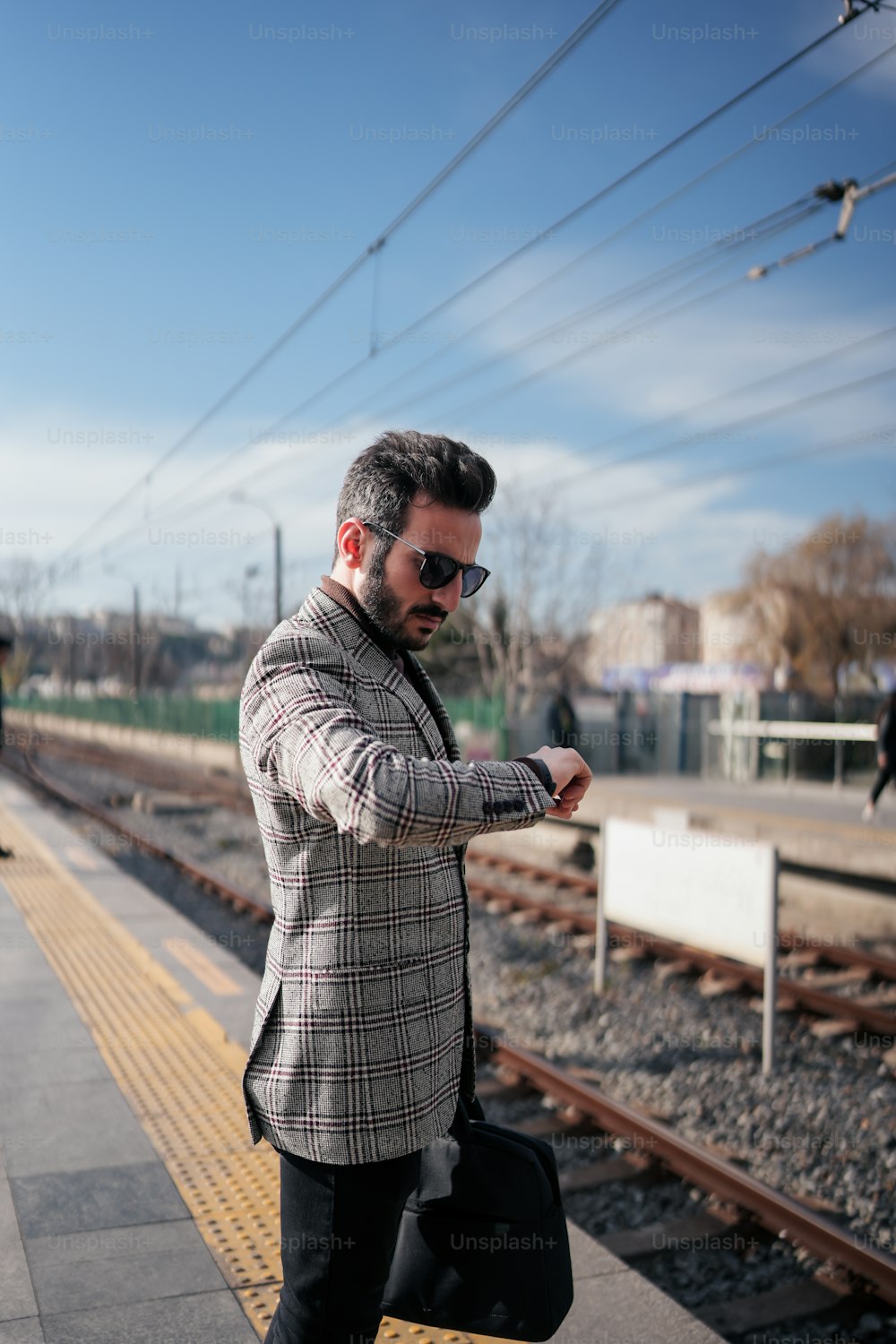 a man standing on a train platform with a suit case