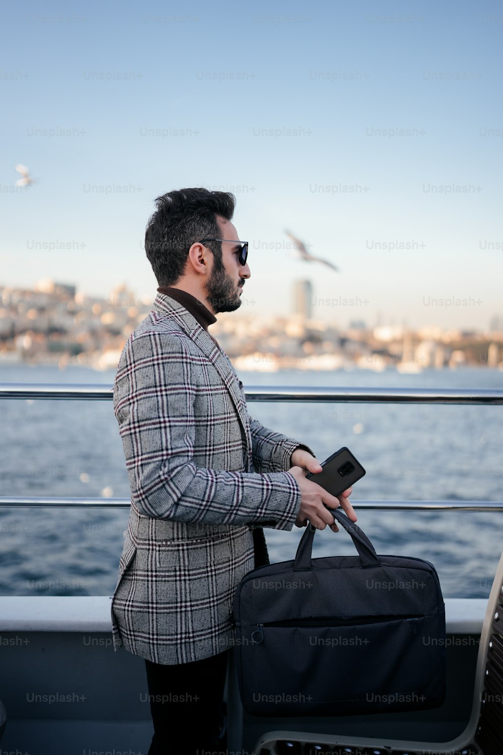 Ein Mann, der auf einem Boot steht und ein Gepäckstück hält