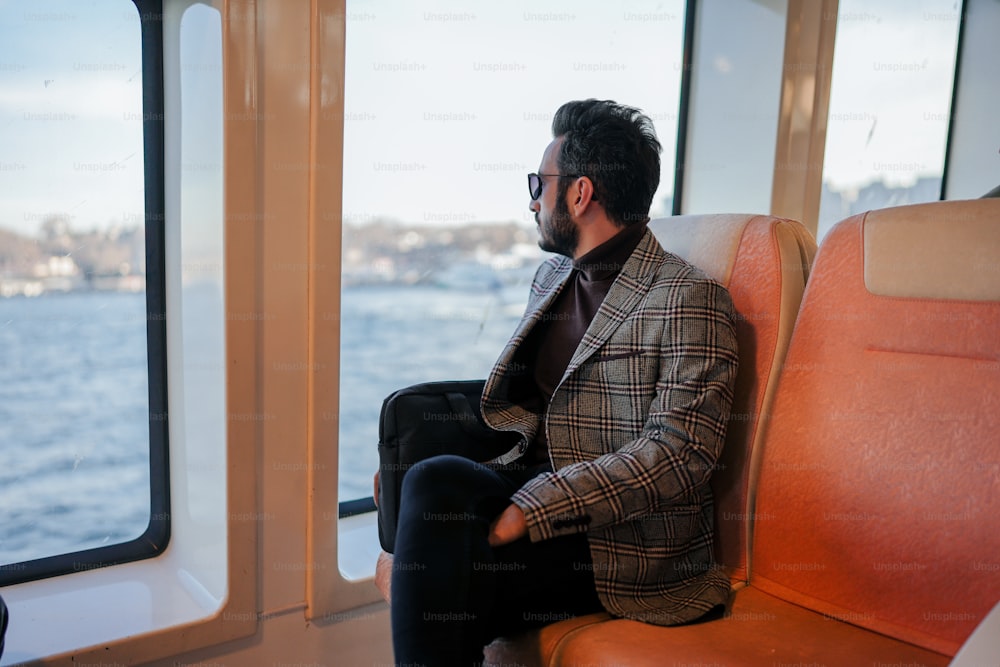 a man sitting on a boat looking out the window