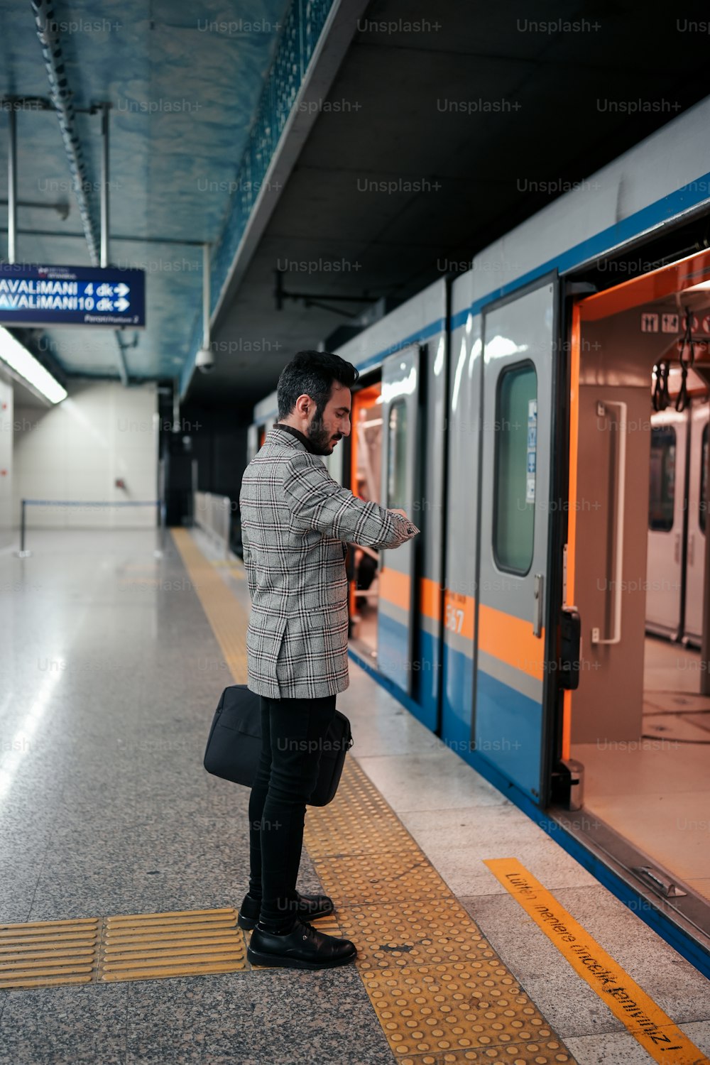 Un uomo in piedi su una piattaforma accanto a un treno