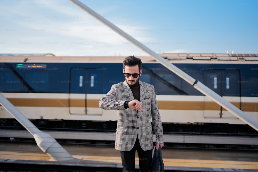 Un uomo in giacca e cravatta che indica un treno