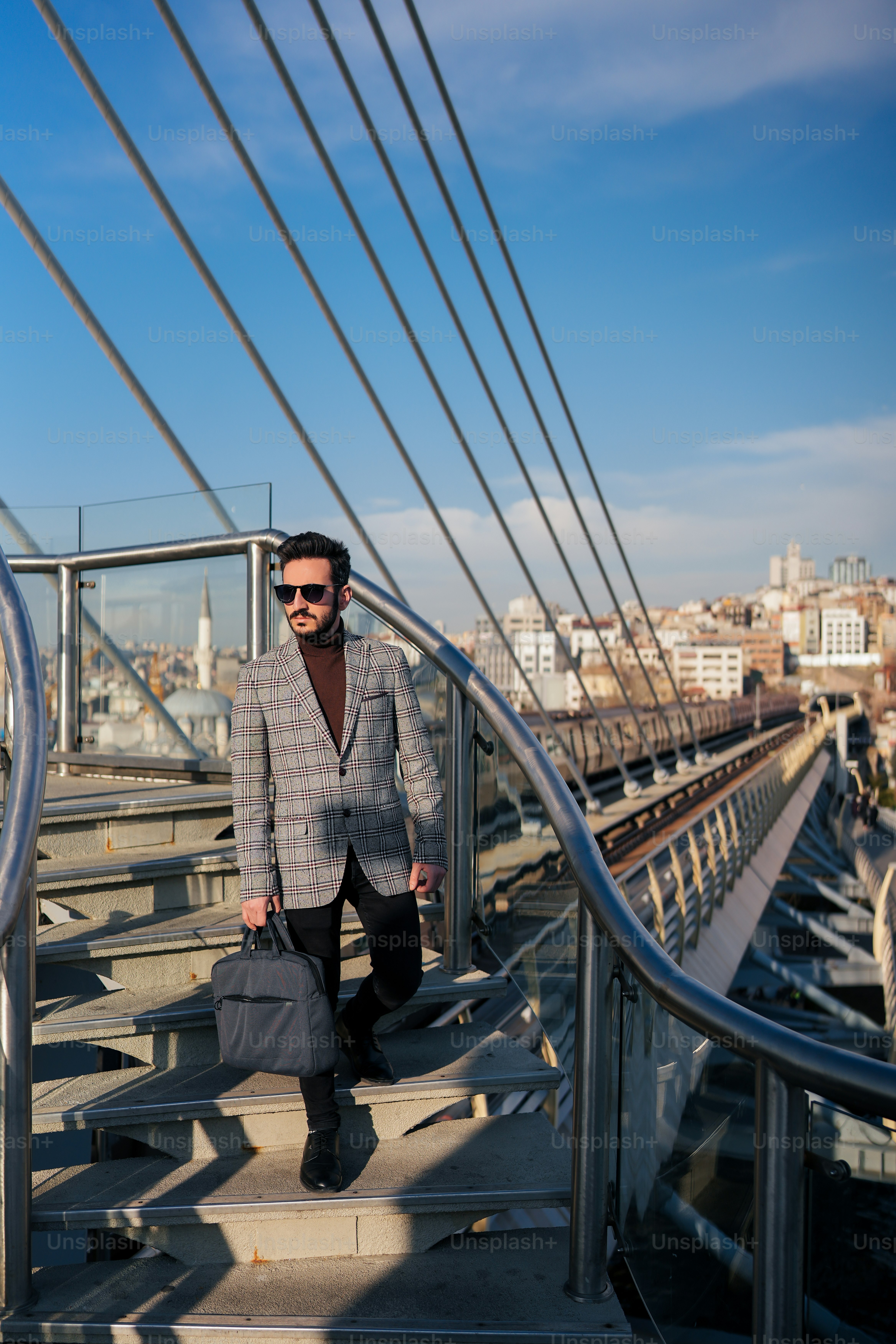 a man in a suit and sunglasses walking up a set of stairs