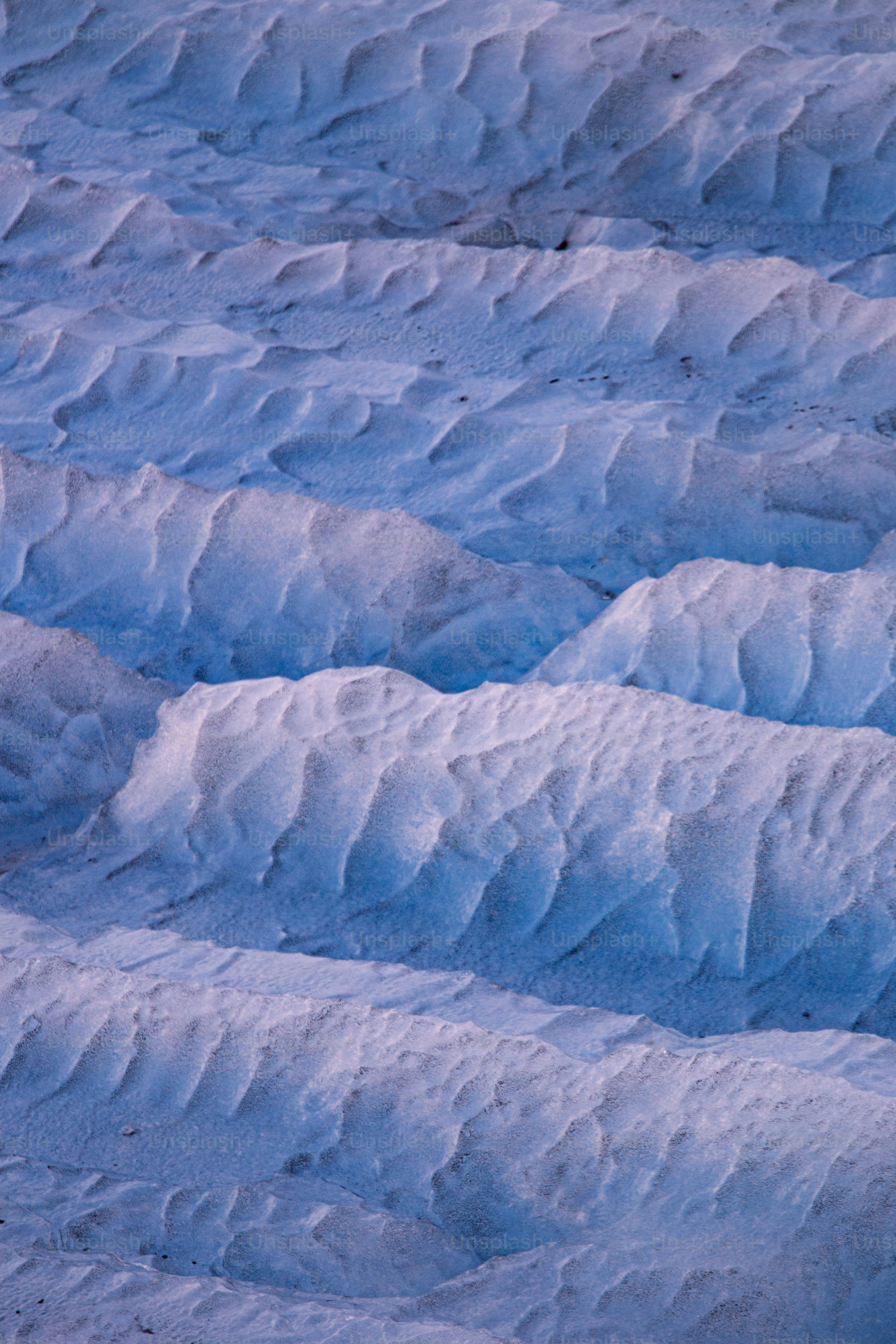 a man riding a snowboard down a snow covered slope