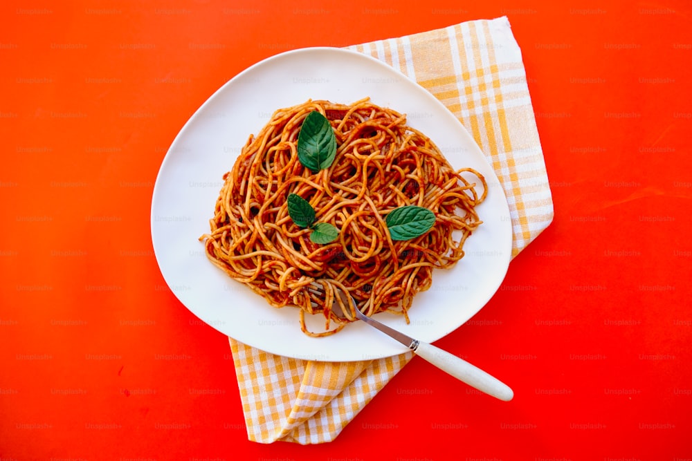 a plate of spaghetti with basil on top