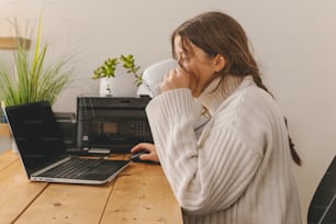 uma mulher sentada em uma mesa com um laptop