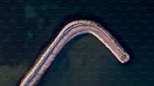 an aerial view of a curved road in the water